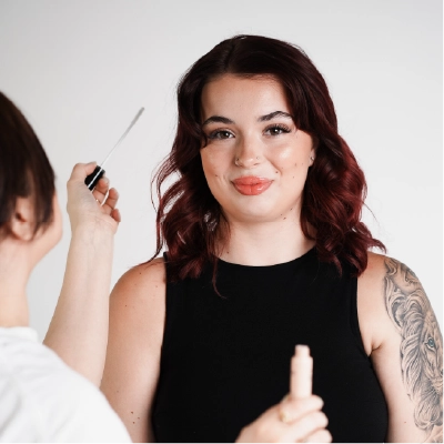 Happy client working with makeup artist for her photoshoot with The Brand Haven